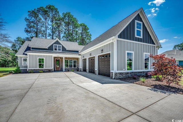 modern inspired farmhouse with driveway, board and batten siding, a porch, a garage, and roof with shingles