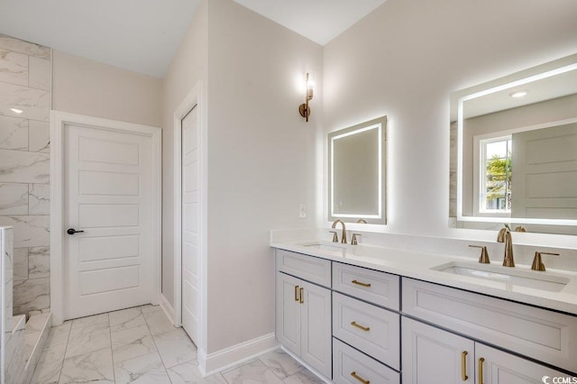 full bath with marble finish floor, baseboards, a sink, and double vanity