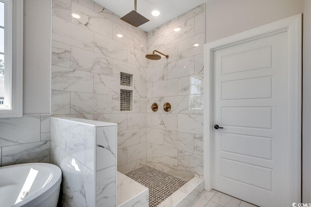 full bath with a soaking tub, marble finish floor, and a tile shower
