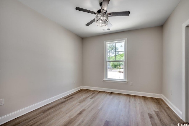 spare room with visible vents, baseboards, a ceiling fan, and wood finished floors
