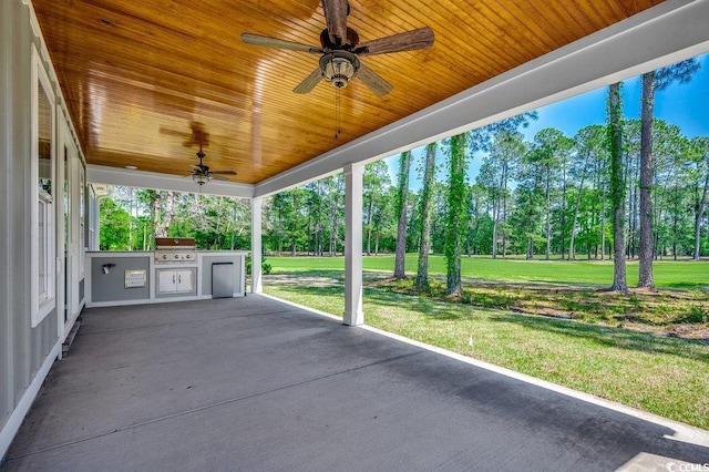 view of patio with an outdoor kitchen, ceiling fan, and grilling area