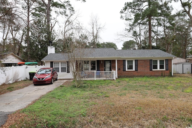 single story home with a porch, a shed, and a front yard