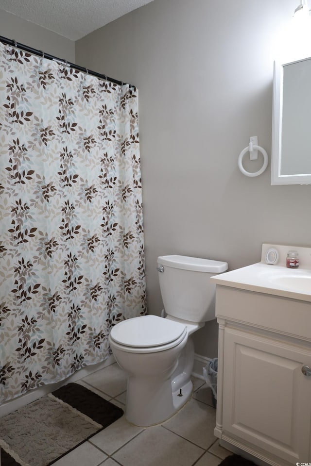 bathroom with tile patterned flooring, vanity, toilet, and a textured ceiling