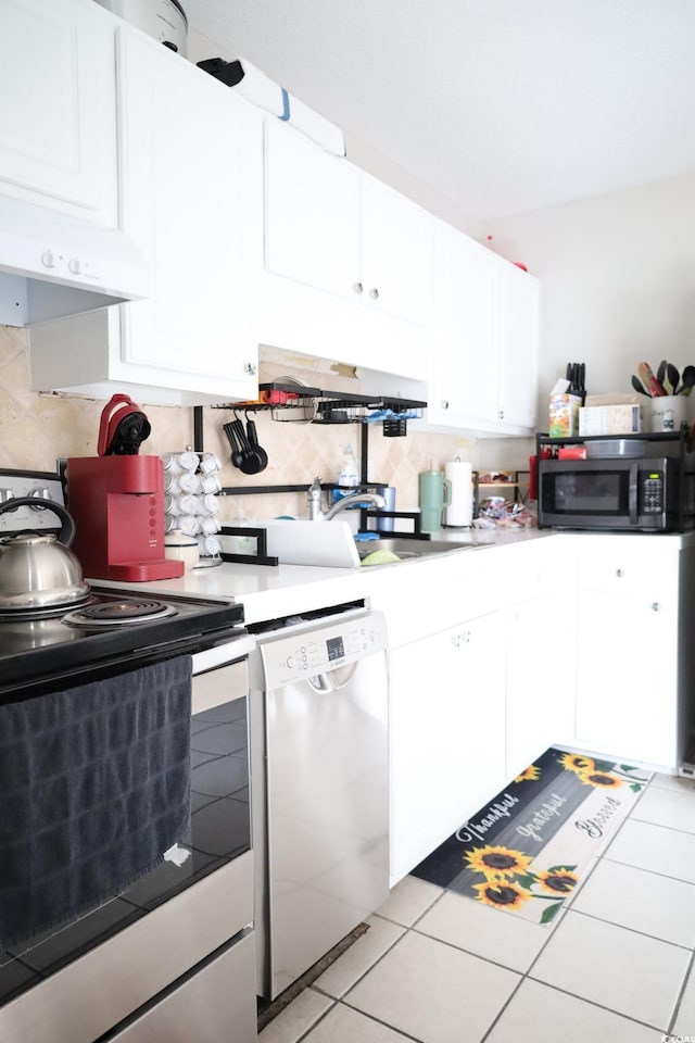 kitchen with appliances with stainless steel finishes, light tile patterned floors, decorative backsplash, and white cabinets