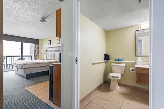 bathroom with vanity, a textured ceiling, tile patterned floors, and toilet