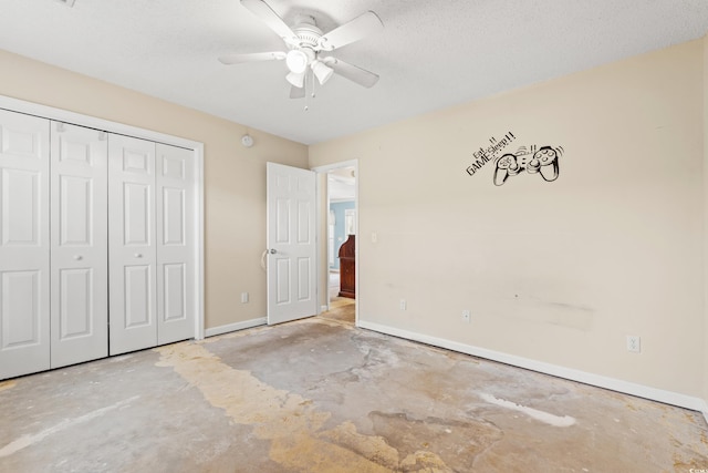 unfurnished bedroom with a textured ceiling, concrete flooring, a closet, and ceiling fan