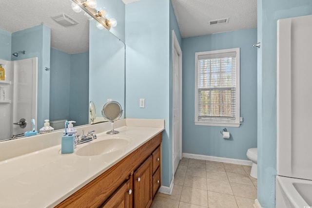 bathroom with vanity, a textured ceiling, tile patterned floors, and toilet