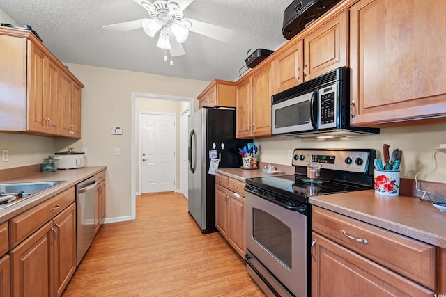 kitchen with ceiling fan, light hardwood / wood-style flooring, a textured ceiling, and appliances with stainless steel finishes