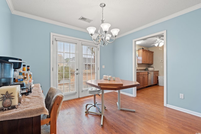 dining area with french doors, sink, crown molding, a chandelier, and light hardwood / wood-style floors