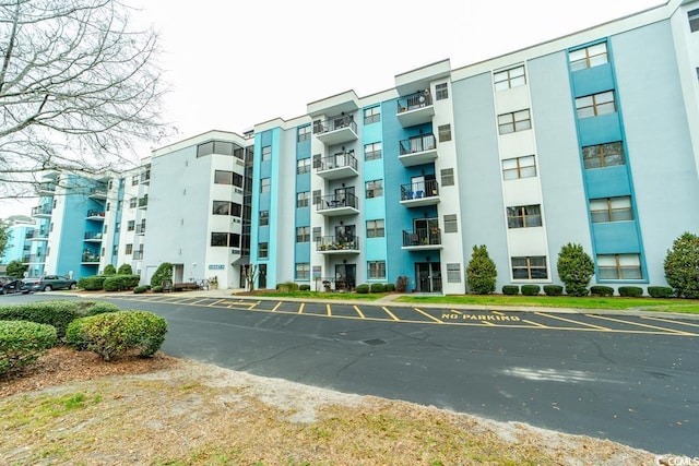 view of building exterior with uncovered parking