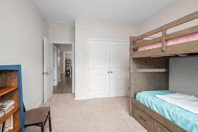 bedroom featuring light colored carpet and a closet