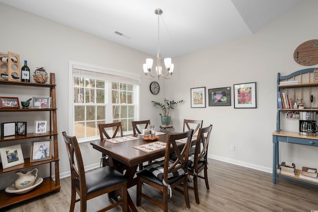 dining room featuring dark wood-type flooring and a chandelier