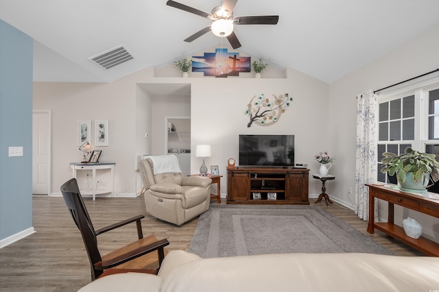 living room featuring wood-type flooring, ceiling fan, and vaulted ceiling