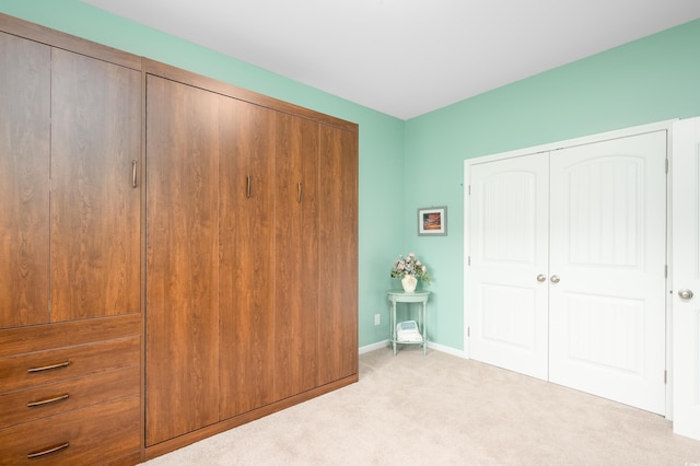 unfurnished bedroom featuring light colored carpet and a closet