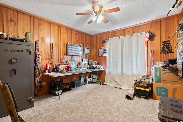 misc room featuring wood walls, light carpet, ceiling fan, and a textured ceiling