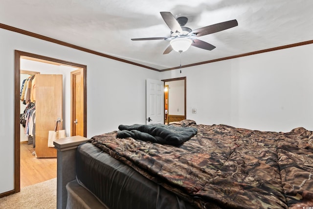 bedroom featuring ornamental molding, light carpet, and a ceiling fan