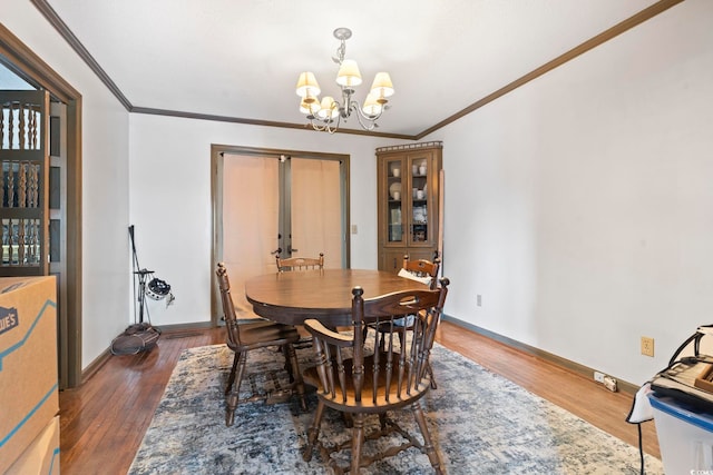 dining space with baseboards, a chandelier, dark wood finished floors, and crown molding