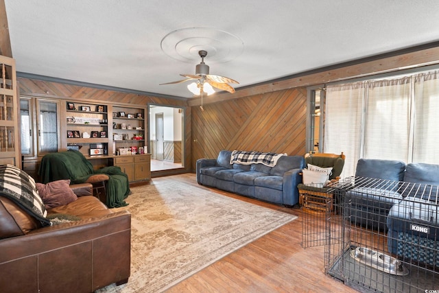 living room featuring plenty of natural light, wood walls, and wood finished floors