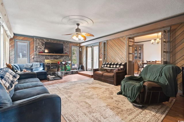 living area featuring french doors, wooden walls, a textured ceiling, and wood finished floors