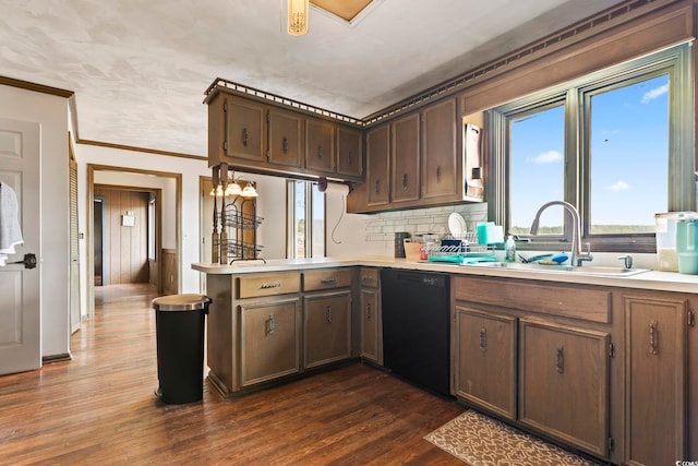 kitchen featuring dishwasher, dark wood-type flooring, a peninsula, light countertops, and a sink