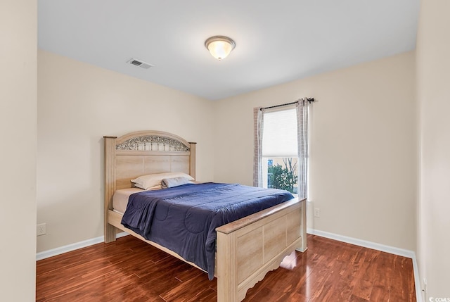 bedroom with dark hardwood / wood-style floors