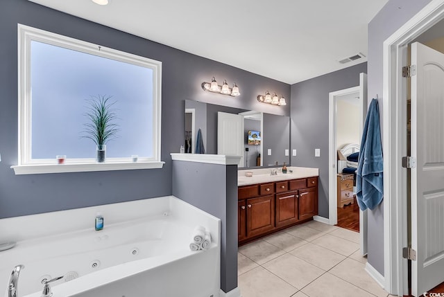 bathroom featuring vanity, tile patterned floors, and a tub to relax in