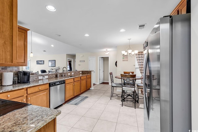 kitchen featuring pendant lighting, light tile patterned floors, light stone countertops, and appliances with stainless steel finishes