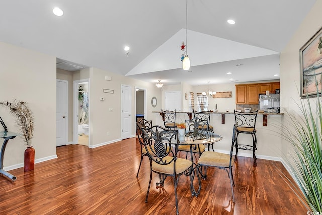 dining area featuring a notable chandelier, wood-type flooring, and high vaulted ceiling