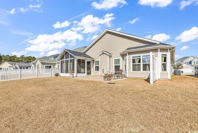 rear view of property with a sunroom, a yard, a patio area, and central air condition unit