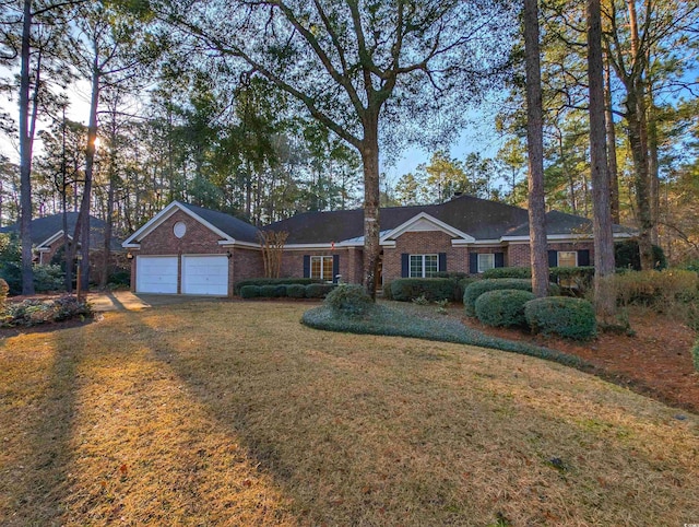 ranch-style house featuring a garage and a lawn