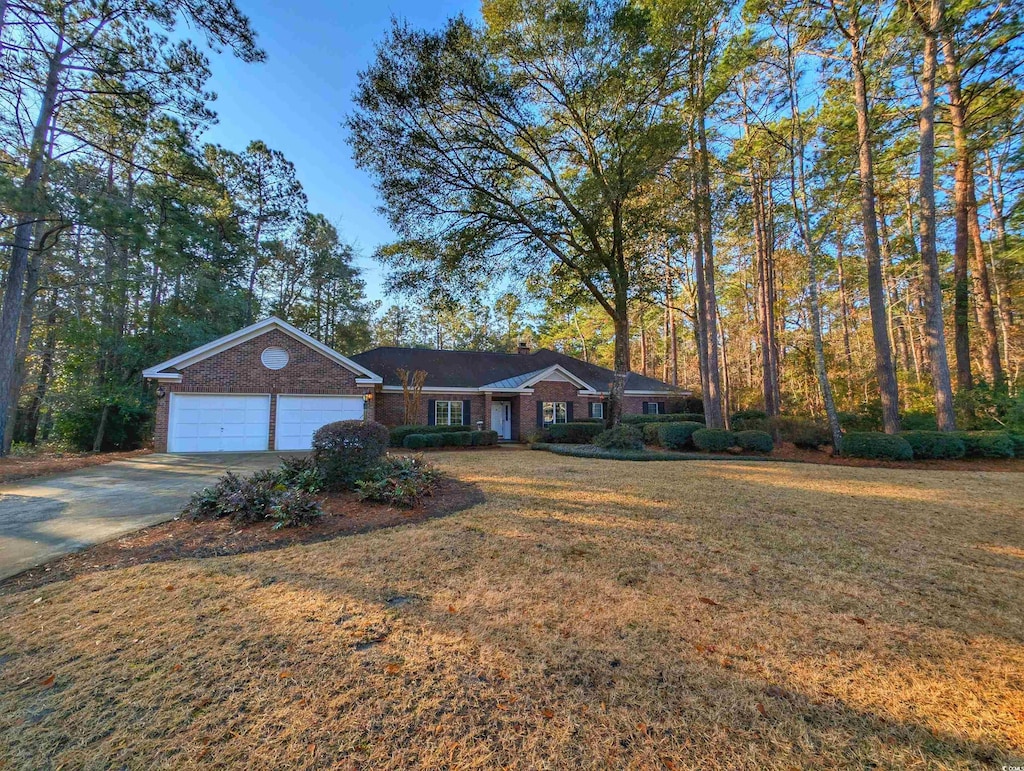 ranch-style house featuring a garage and a front lawn