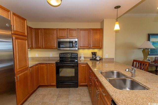 kitchen featuring appliances with stainless steel finishes, light stone countertops, sink, and hanging light fixtures