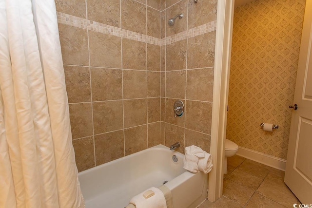 bathroom featuring tile patterned floors, toilet, and shower / bath combo with shower curtain