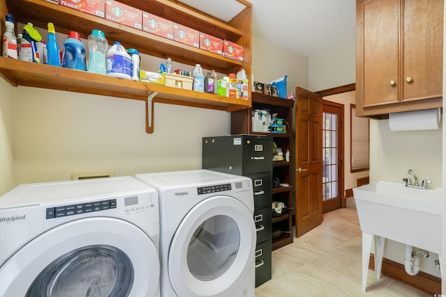 laundry area featuring cabinets, sink, and washing machine and clothes dryer