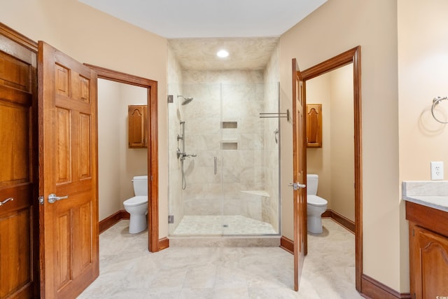 bathroom with vanity, a shower with door, and toilet