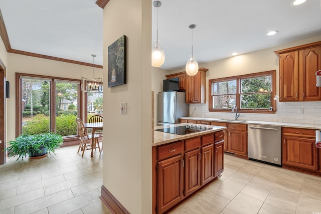 kitchen with pendant lighting, sink, decorative backsplash, and stainless steel appliances