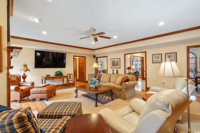 living room featuring crown molding, ceiling fan, and light wood-type flooring