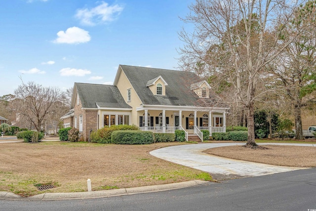 cape cod house featuring a front yard and covered porch