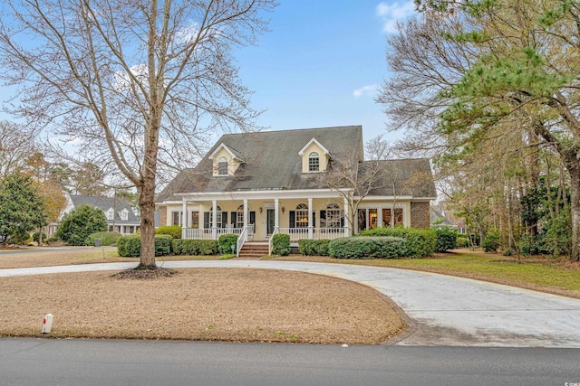 new england style home with covered porch and a front yard