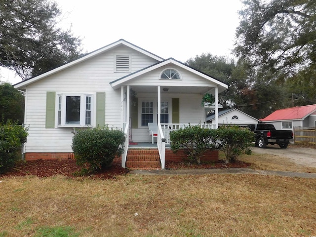 bungalow-style home with a porch and a front yard