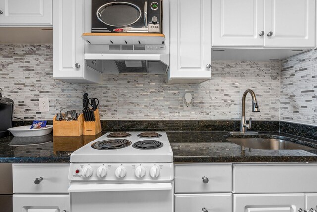 kitchen featuring white cabinetry, sink, dark stone counters, light wood-type flooring, and electric stove