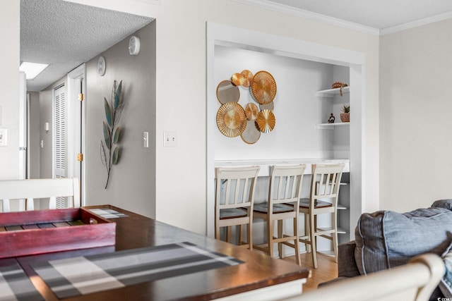 interior space with hardwood / wood-style flooring, ornamental molding, and a textured ceiling