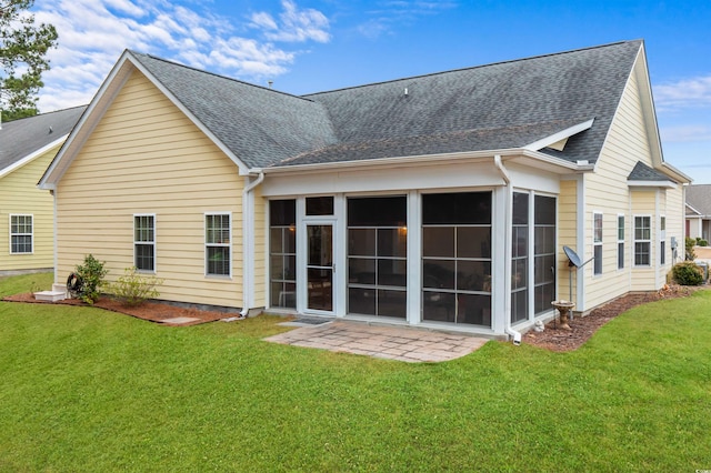 rear view of house with a yard, a patio, and a sunroom