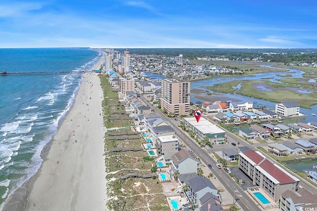 birds eye view of property with a water view and a beach view