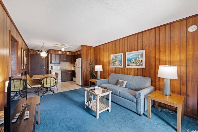 living room with light carpet, a textured ceiling, and wood walls