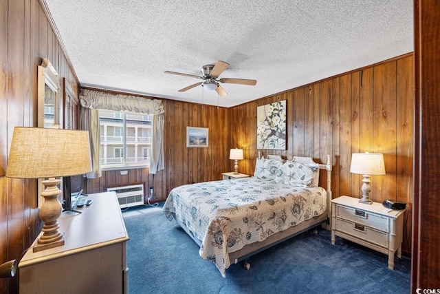 carpeted bedroom with ceiling fan, a wall mounted air conditioner, a textured ceiling, and wood walls