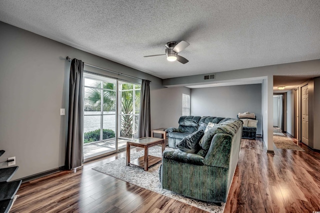 living room featuring hardwood / wood-style flooring, a textured ceiling, and ceiling fan