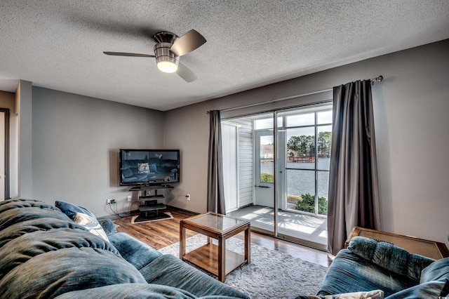 living room featuring hardwood / wood-style flooring, ceiling fan, plenty of natural light, and a textured ceiling