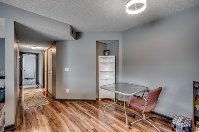 office area with hardwood / wood-style floors and a textured ceiling