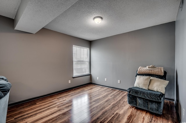 living area with wood-type flooring and a textured ceiling